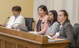Nedra Robinson, Marielynn Herrera, Chandra Bittman, and Representative Bahner sit at the testifiers' table and look at someone out of view.